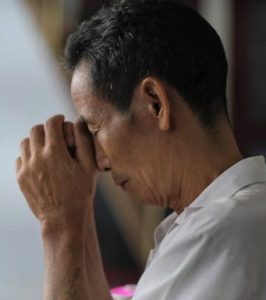 man praying with hands together